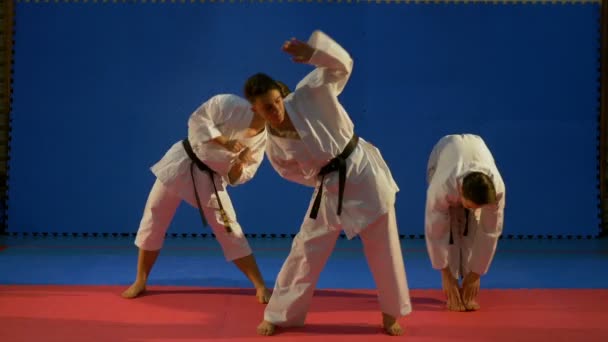 Jongens doen warm up en spieren voordat karate opleiding uit te rekken — Stockvideo