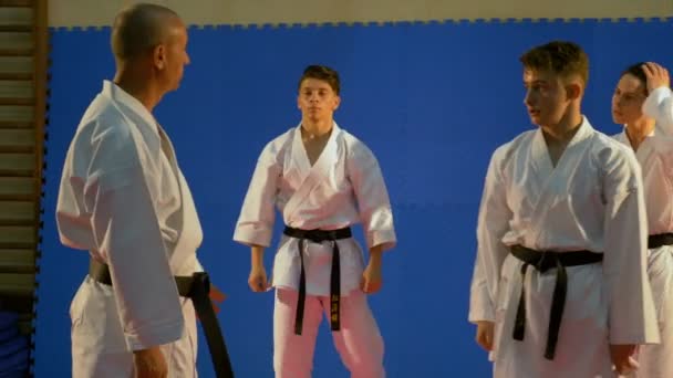 Sensei Karate Lehrer im Gespräch mit seinem Team von Studenten im Dojo während des Trainings für den Wettbewerb — Stockvideo