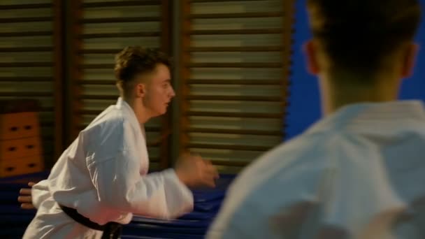 Attack karate sequence with spectacular jump towards adversary performed by young fighter at the dojo — Stock Video