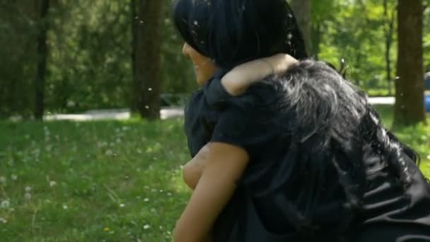 Jonge moeder knuffelen en roterende haar zoon slow-motion in de natuur — Stockvideo