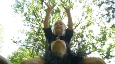 Annesiyle gülen ve having fun sırtına oturan küçük oğlu