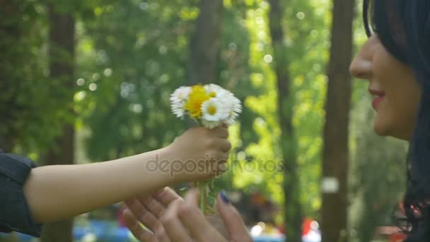 Cute boy offering to mom flowers with love and giving her a kiss — Stock Video