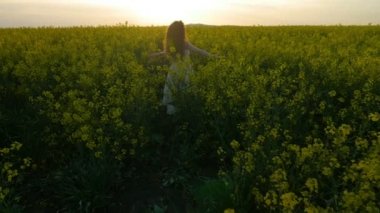 Yavaş hareket olan iplik ve kolza tohumu alan doğada yaz kutluyor çekici genç kadın