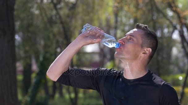 Бегун проводит интенсивные тренировки в парке питьевой воды и льет на лицо, чтобы освежить себя в замедленной съемке — стоковое видео