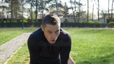Mola için durdurma ve nefes yakalamak adam jogging yapan smartwatch bir parkta çalıştırmaya başlayan yarış zamanında kontrol etmek için uygun