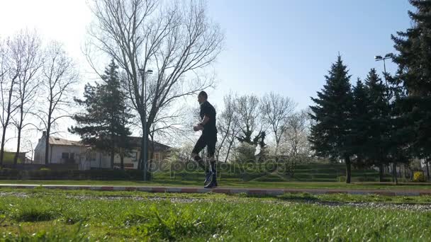 Joven atleta masculino trabajando piernas antes de trotar entrenamiento — Vídeo de stock