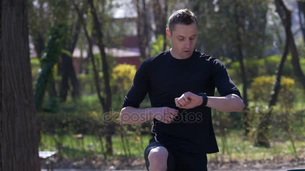 Atleta attivo guardando smartwatch tracker attività cardiofrequenzimetro — Video Stock