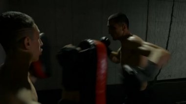 Ağır çekim genç sporcuların spor salonu yastıkları Delme Tay dili kullanarak kickboks maçı için eğitim