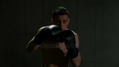 Profesyonel erkek boxer eğitim yumruklar ve mücadele hamle spor stüdyosunda