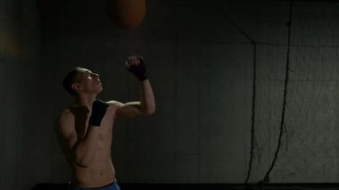 Kick boks spor salonu studio sarılı el ile içindeki eğitim oturumunda bir top Delme ağır çekim