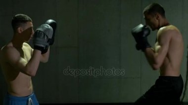 Konsantrasyon ve kararlılık ile boks Studio'da eğitim iki erkek kickboks savaşçıları