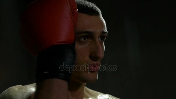 Movimiento lento de kickboxer sudado limpiando con guantes agua de su cara cansada después de la pelea — Vídeo de stock