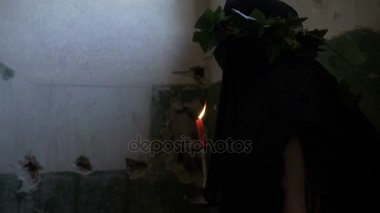 Üst katta yürüyüş ve karanlık bir terk edilmiş odada girerek onun elinde bir mum tutan kederli korkmuş kadın giyinmiş