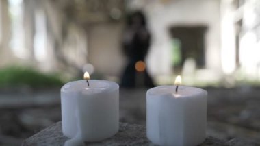 Kara büyü ve mum ruhları çağırma el sallayarak uzun siyah saçlı güzel cadı