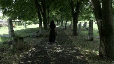 Cenaze Gotik dul kadın elinde eski mezarlık sokakta yürüyen bir taç tutarak siyah düşmüş ağaç yaprakları ile dolu