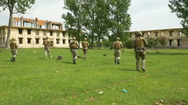 Soldati in missione che camminano verso l'obiettivo nella zona rurale con edifici in rovina abbandonati — Video Stock