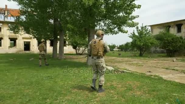 Tropas de intervención del ejército asignadas a patrullar una zona rural con edificios devastados por el conflicto — Vídeo de stock