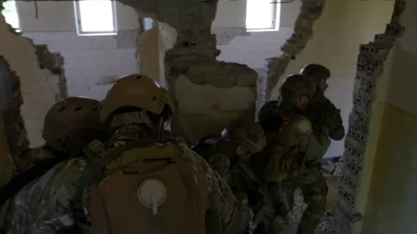 Trabalho em equipe de uma unidade militar especial descendo escadas durante uma intervenção operacional armada em um prédio abandonado — Vídeo de Stock