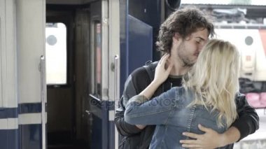 Veda ve yağmurlu günde tren istasyonu platformu üzerinde öpüşme aşk güzel Çift