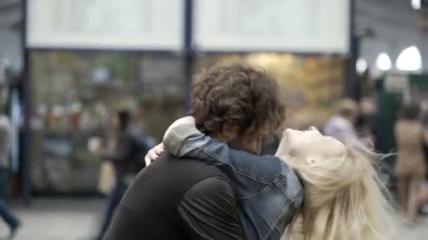 Pareja reunida con una chica joven corriendo para encontrarse con su novio besándose y abrazándose para reunirse en la estación de tren del aeropuerto — Vídeos de Stock