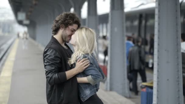 Pareja adolescente enamorada cosquillas y besándose en la estación de tren divirtiéndose antes de la salida esperando el tren — Vídeo de stock