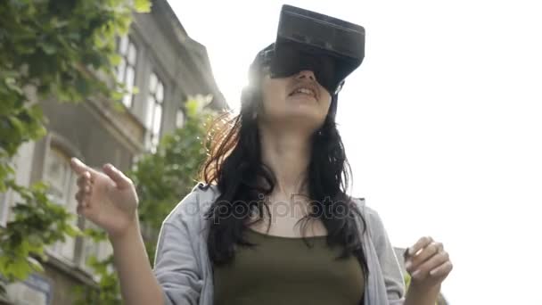 Junge Frau spielt ein Virtual-Reality-Spiel im Freien überraschende vr Erfahrung — Stockvideo