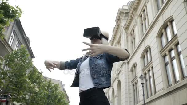 Молодая привлекательная женщина танцует балет в общественном месте с виртуальной реальностью vr гарнитура — стоковое видео
