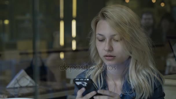 Gyönyörű üzleti nő textil a szociális média a smartphone, miközben eszik fagylaltot a kocsmában vár — Stock videók