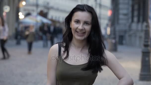 Портрет красивой брюнетки с разными выражениями лица на городской площади — стоковое видео