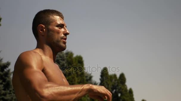 Uomo atletico assetato versa acqua in bocca dopo l'allenamento — Video Stock