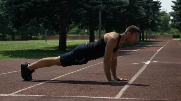 Спортивный спортсмен отжимается на беговой дорожке — стоковое видео