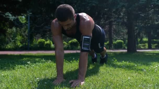 Culturista ejercitando los músculos del pecho en el parque temprano en la mañana — Vídeos de Stock
