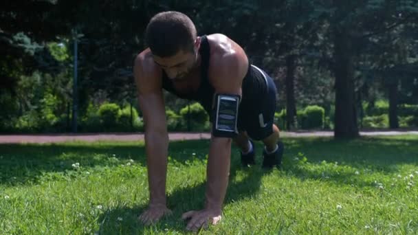 Culturista ejercitando los músculos del pecho en el parque temprano en la mañana — Vídeo de stock