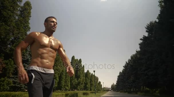 El ajuste muscular del culturista se toma un descanso durante el ejercicio al aire libre — Vídeo de stock