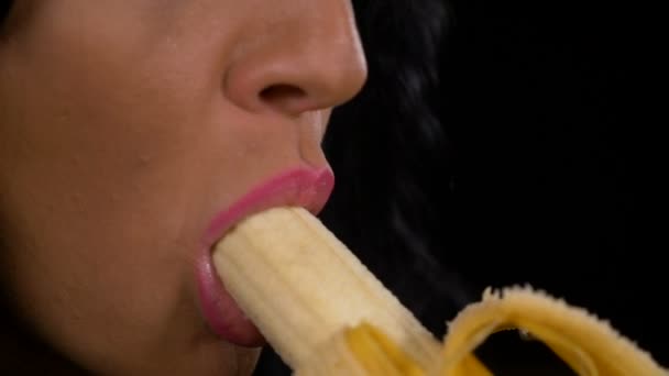 Медленное движение сексуальной молодой женщины соблазнительно съедающей свежий банан — стоковое видео