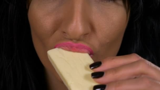 Primer plano de sensuales labios femeninos degustación de chocolate blanco — Vídeos de Stock