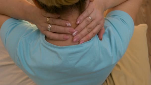 Top view of middle aged woman rubbing back of neck healing the pain and stiffness — Stock Video