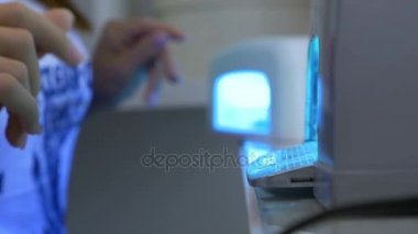 Kadın manikür işlem sırasında Uv lambaları ellerini koyar