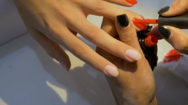 Kırmızı tırnak cilası uygulayarak manikür yordamı ile yakın çekim