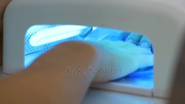 Primo piano con la mano della donna in lampada UV durante la procedura di manicure professionale — Video Stock