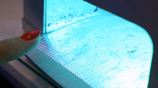 Gros plan du pouce dans la lampe UV pendant la manucure professionnelle semi-permanente — Video