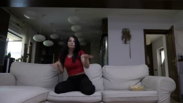 Tonåring dansar på en soffa på rapmusik när hennes favoritlåt börjar på Tv — Stockvideo