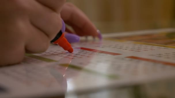 Nahaufnahme einer jungen Frau, die mit rotem Marker die Daten der Präventionsgeburten auf dem Kalender markiert und zählt — Stockvideo