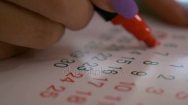Tarih ve takvimdeki günlerin kırmızı marker ile işaretleme kadın el closeup