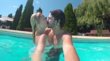 Çift öpüşme ve mutlu bir şekilde sarılma su video fotoğrafı çekerken