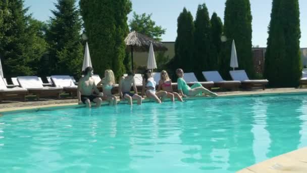 Grupo de amigos tomar banho de sol e relaxar à beira da piscina — Vídeo de Stock