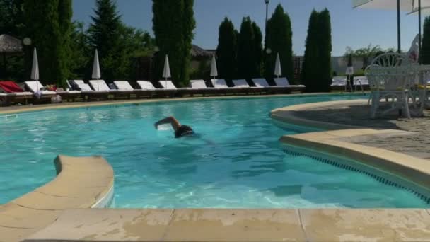 Giovane bel ragazzo esce dalla piscina dopo una nuotata — Video Stock