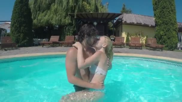Pareja jugando y besándose románticamente en la piscina bajo el agua — Vídeo de stock