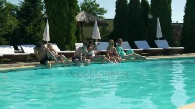 Grup havuz ve bir adam tarafından rahatlatıcı arkadaşıyla herkes ıslak suya atlar