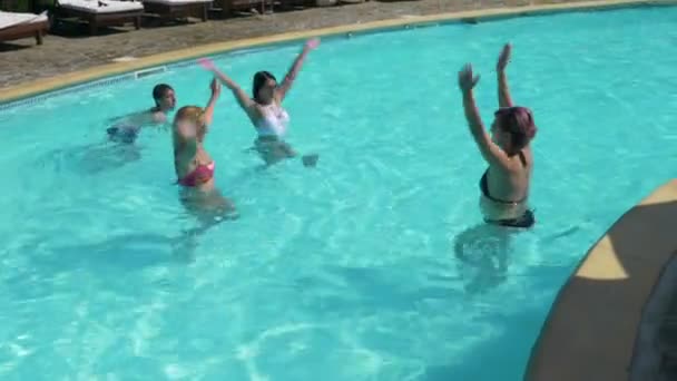 Lányok csinálás fitness gyakorlatok a medencében a víz, és a srác elhalad, és megáll, hogy néz ki — Stock videók